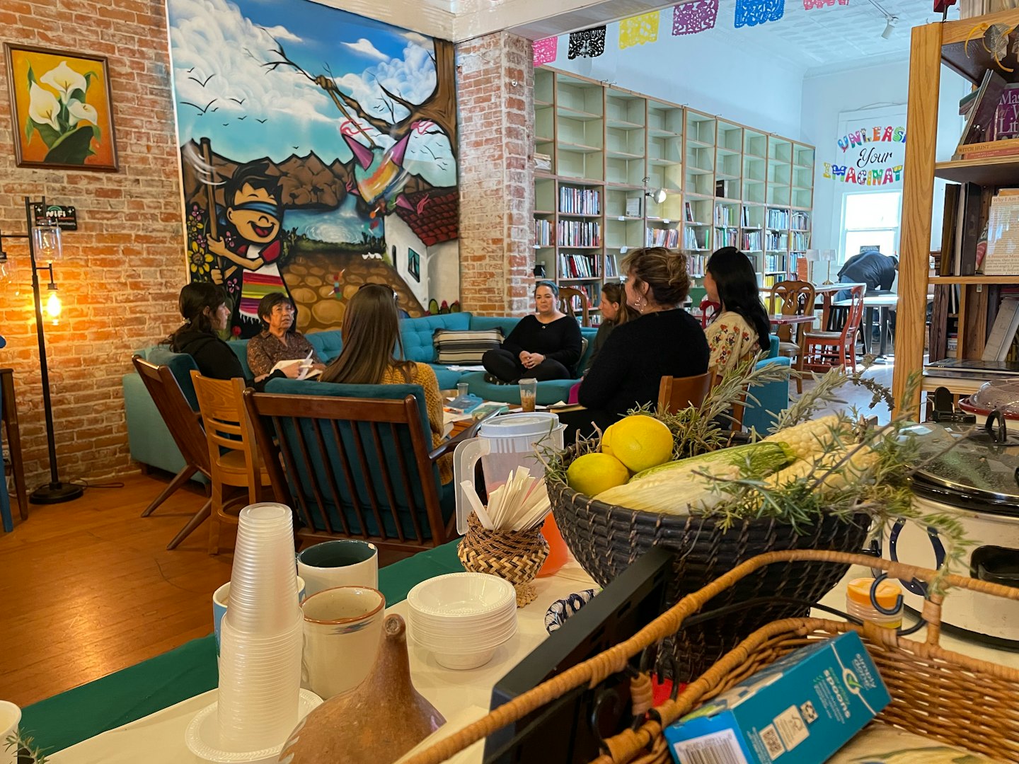 A group of women discuss ideas around a table in a creative office.